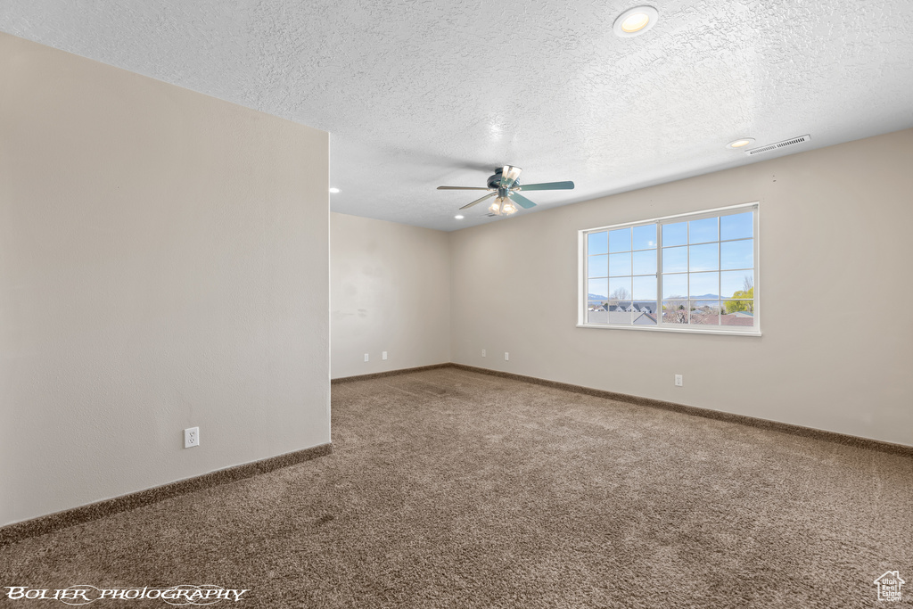 Carpeted spare room with a ceiling fan, a textured ceiling, baseboards, and recessed lighting