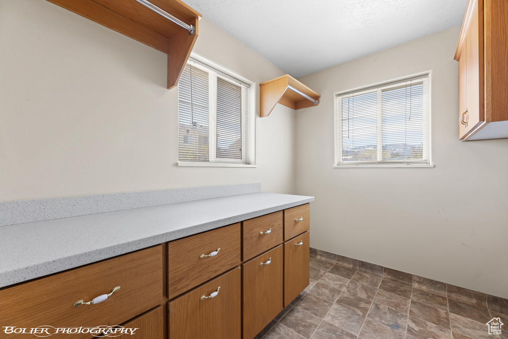 Walk in closet featuring stone finish floors