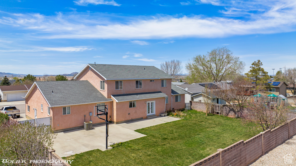 Back of house featuring stucco siding, a patio area, roof with shingles, and a residential view