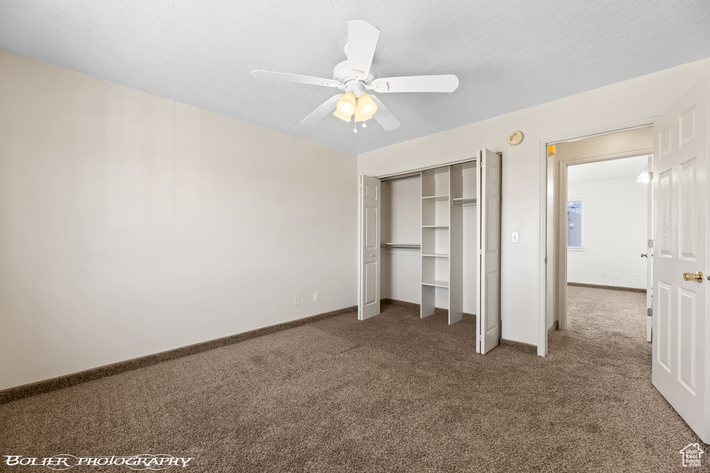 Unfurnished bedroom featuring carpet, a closet, baseboards, and a ceiling fan
