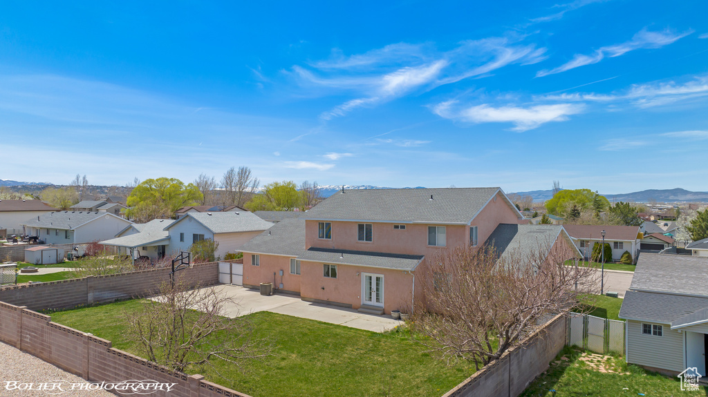 View of front of property with a residential view, stucco siding, a patio area, and a shingled roof
