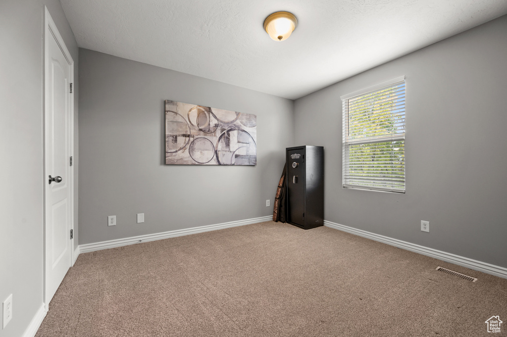 Spare room featuring carpet and baseboards