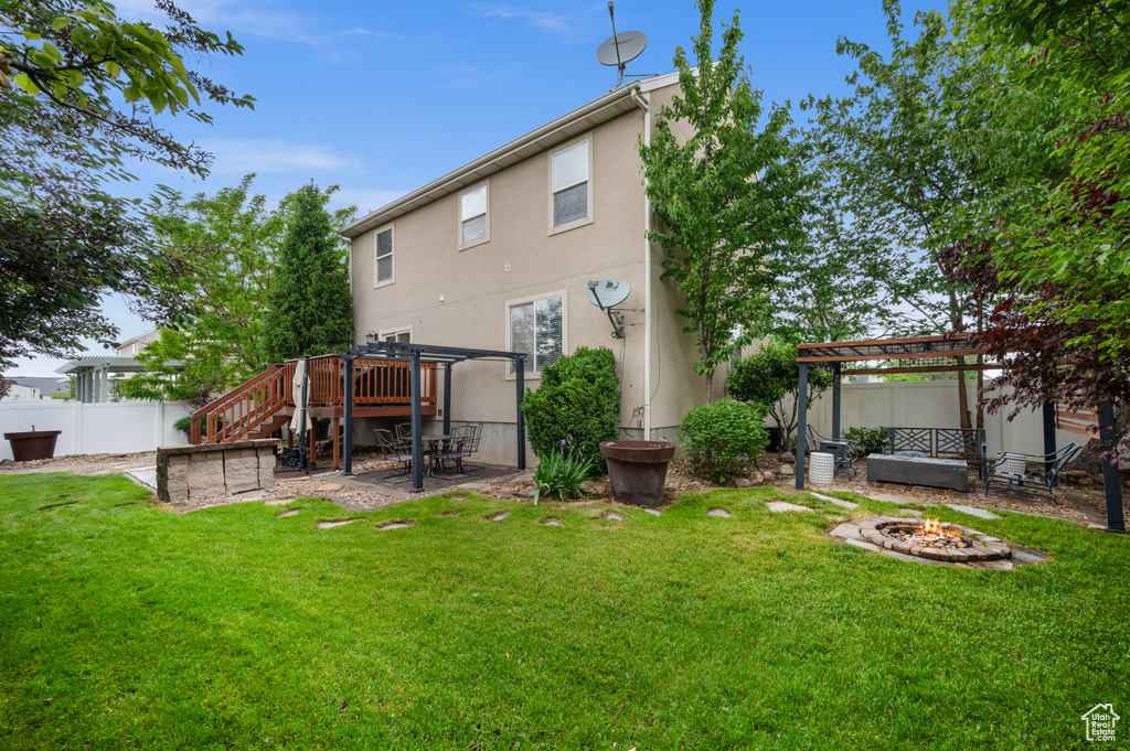 Back of house featuring an outdoor fire pit, a pergola, stucco siding, a patio area, and stairway