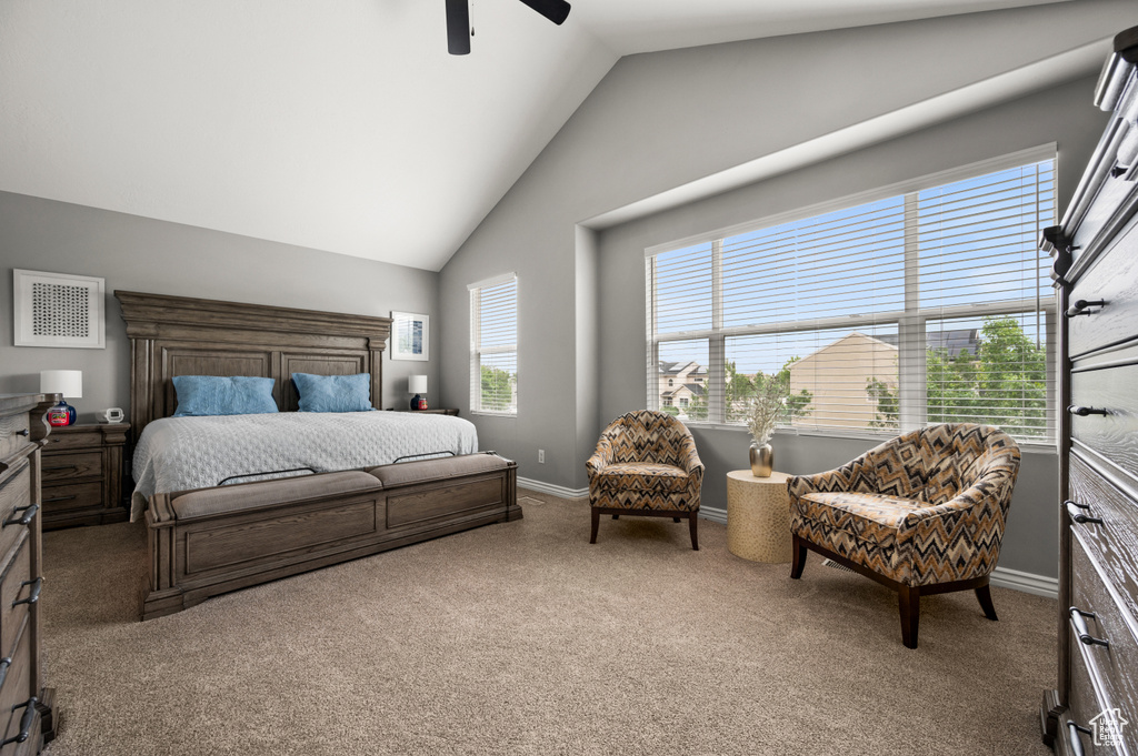 Carpeted bedroom featuring baseboards, a ceiling fan, and high vaulted ceiling