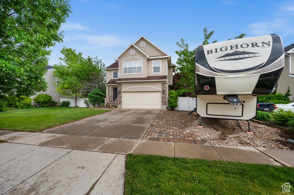 Traditional-style house with concrete driveway, a garage, and stucco siding