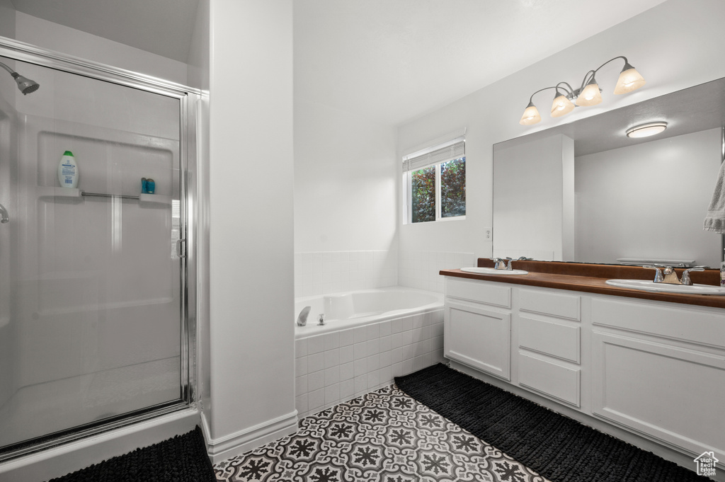 Full bathroom featuring a stall shower, a bath, double vanity, and tile patterned flooring