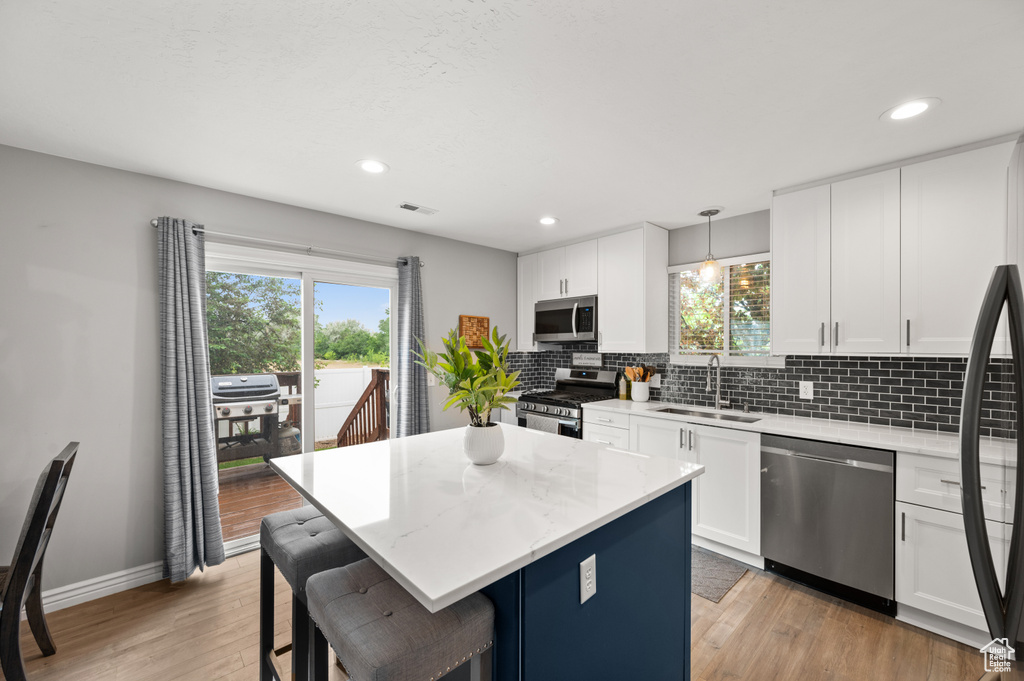 Kitchen featuring appliances with stainless steel finishes, a sink, healthy amount of natural light, backsplash, and recessed lighting