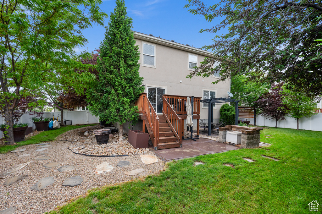Back of house featuring a fire pit, a patio, stucco siding, a pergola, and a deck