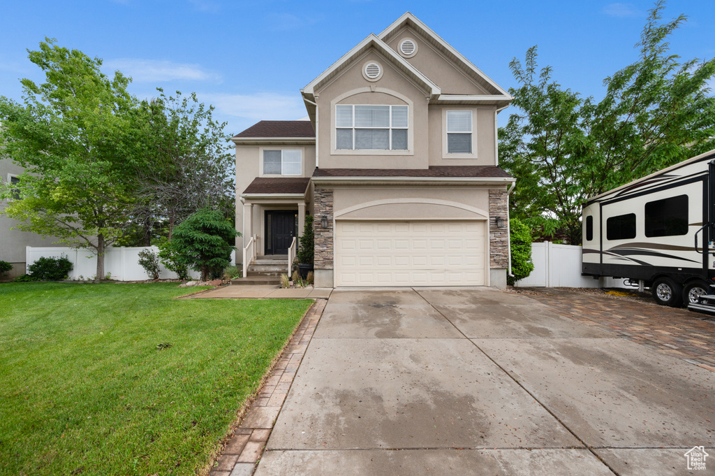 View of front of home featuring stucco siding, an attached garage, driveway, and stone siding