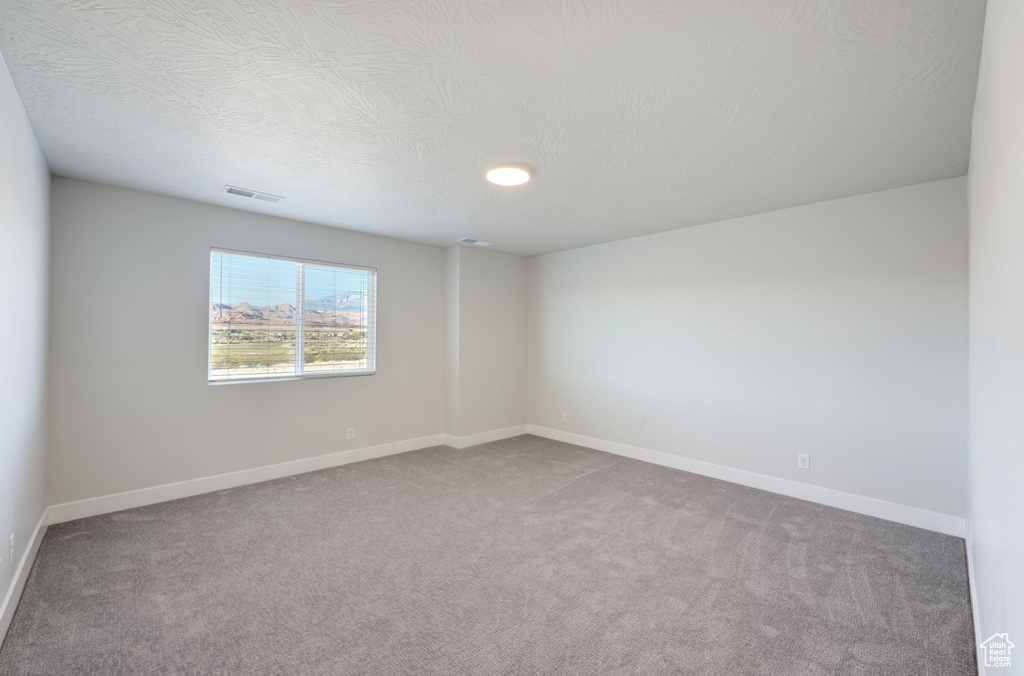 Unfurnished room featuring carpet and baseboards