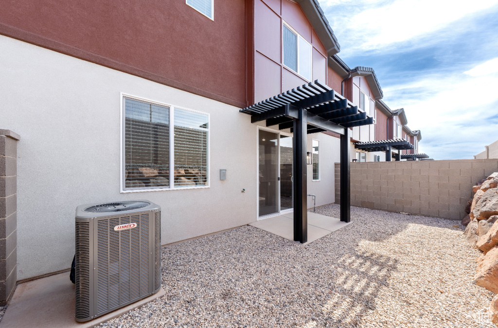 View of patio featuring cooling unit and fence