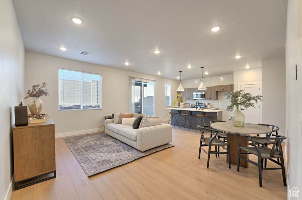 Living area with light wood finished floors, baseboards, and recessed lighting