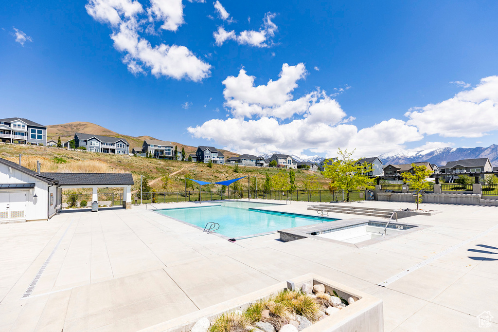 Community pool featuring a residential view, fence, and a patio area