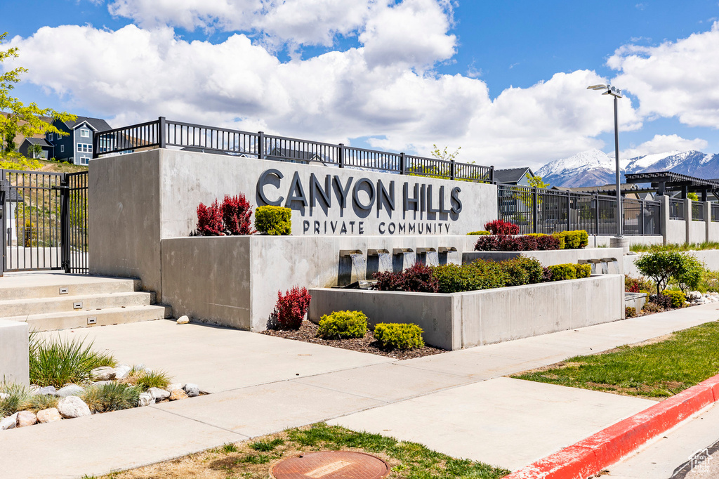 Community / neighborhood sign featuring fence and a mountain view