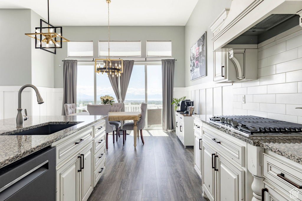 Kitchen featuring a chandelier, a sink, dishwashing machine, stainless steel gas cooktop, and premium range hood