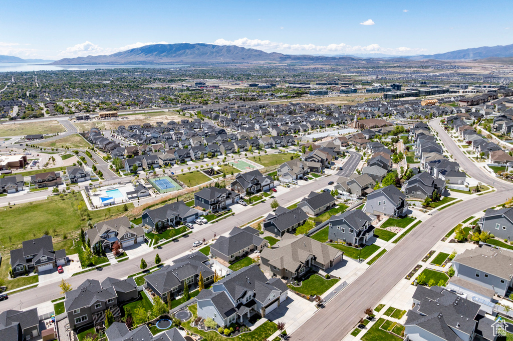 Aerial view of property and surrounding area with a mountain backdrop and nearby suburban area