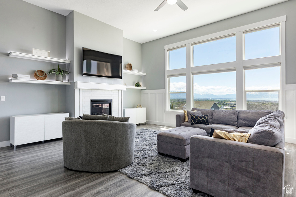 Living area with wood finished floors, a fireplace, and ceiling fan