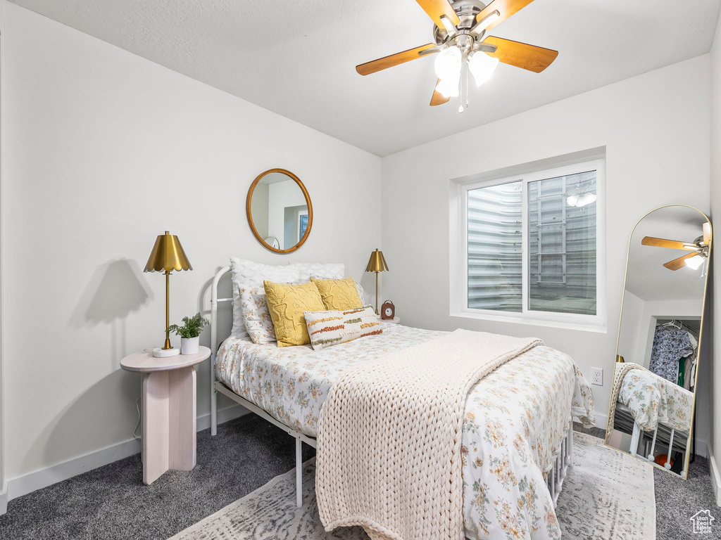 Carpeted bedroom featuring baseboards and ceiling fan
