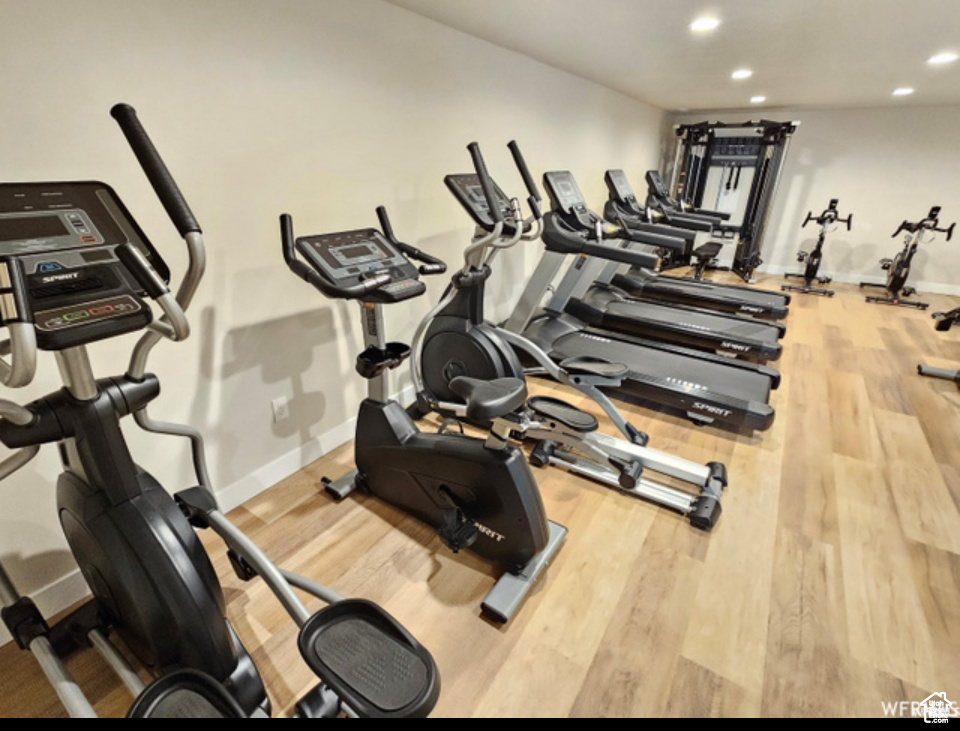 Gym with recessed lighting, wood finished floors, and baseboards