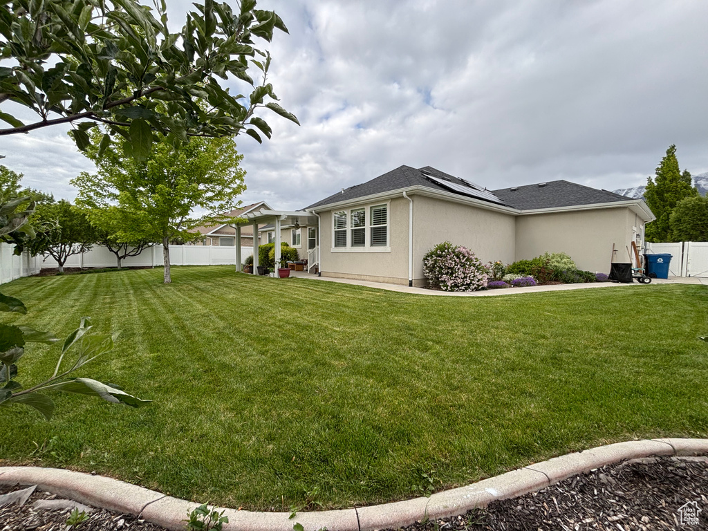 View of property exterior with solar panels and stucco siding