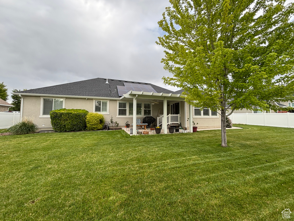 Rear view of house featuring a ceiling fan, a patio, stucco siding, and roof with shingles