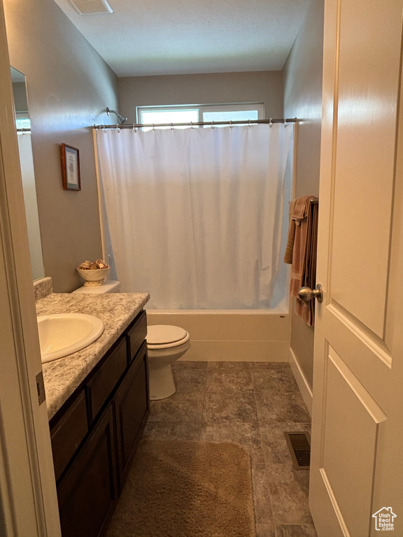 Full bath with vanity, shower / tub combo, and toilet