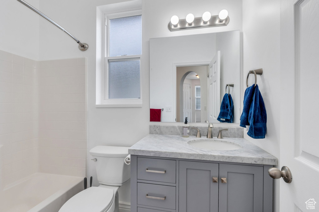 Full bath with toilet, vanity, and bathing tub / shower combination