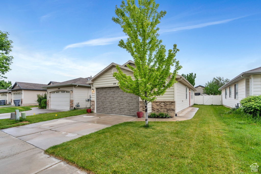 Ranch-style home featuring a garage, driveway, and brick siding