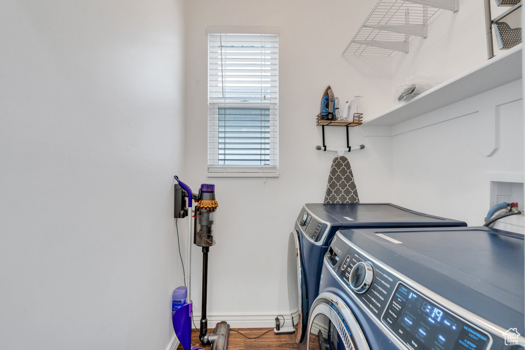 Laundry room featuring independent washer and dryer, baseboards, and wood finished floors