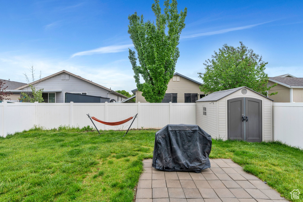 View of yard featuring a storage shed, an outdoor structure, and a patio area
