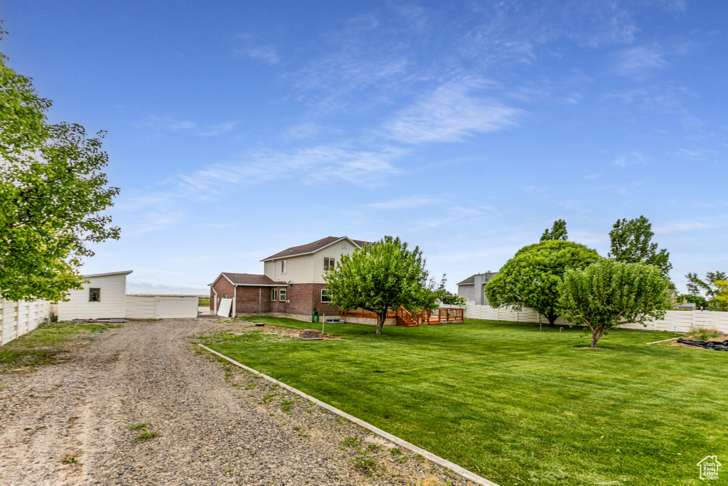 View of yard with an outbuilding and gravel driveway