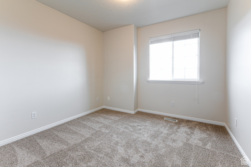 Carpeted empty room with baseboards