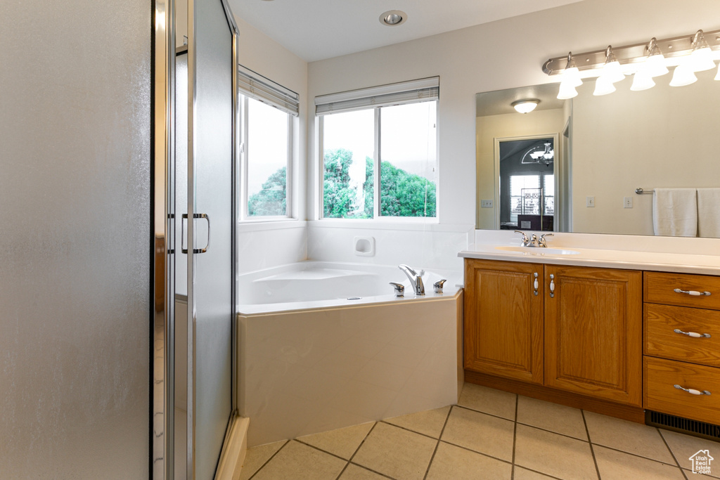 Full bath with vanity, a shower stall, a bath, and tile patterned flooring