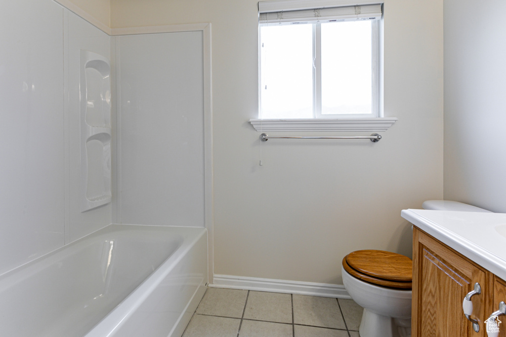 Full bathroom with tile patterned floors, toilet, vanity, and baseboards