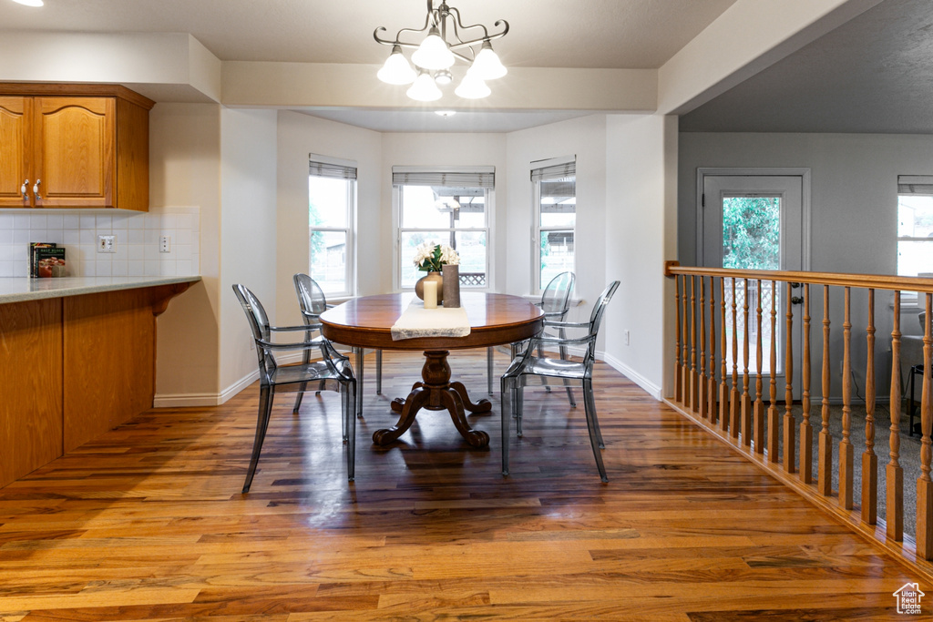 Dining space with a chandelier, light wood-style floors, and baseboards