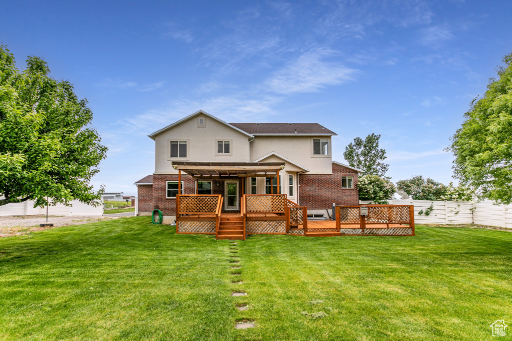 Rear view of house with stucco siding, a deck, and brick siding