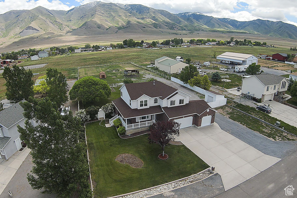Aerial view of property and surrounding area with a mountain backdrop