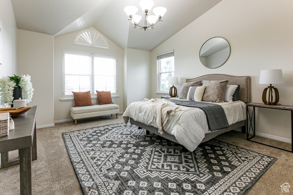 Carpeted bedroom featuring a chandelier, vaulted ceiling, and baseboards