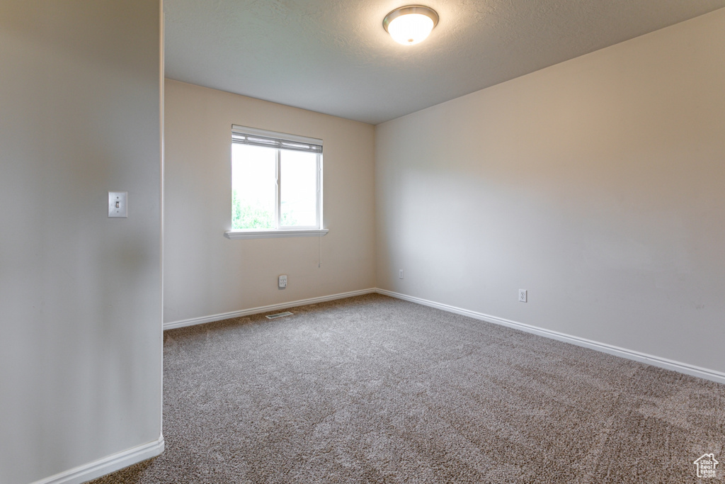 Carpeted empty room with baseboards