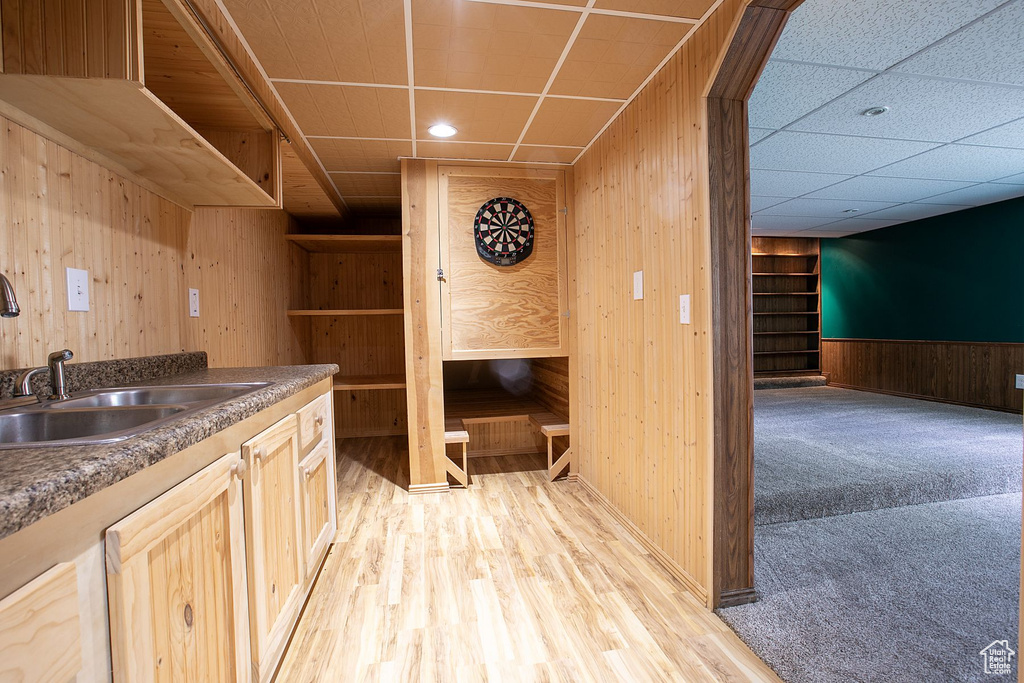 Bar area featuring wood walls, a sink, light wood finished floors, baseboards, and recessed lighting