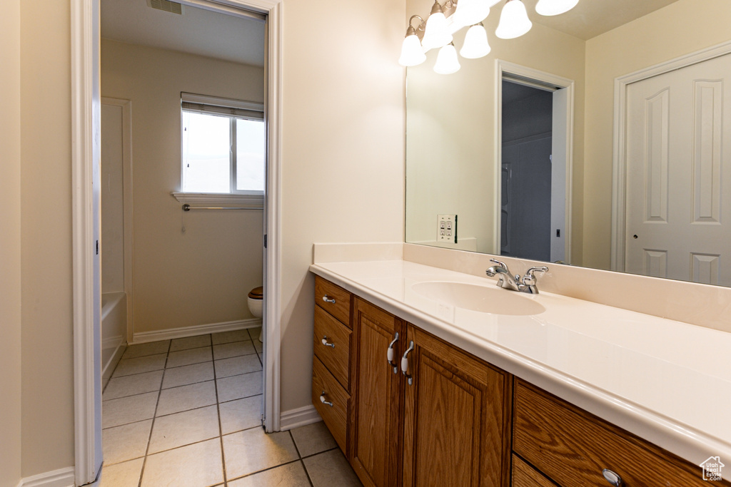 Full bathroom featuring toilet, tile patterned floors, vanity, and baseboards