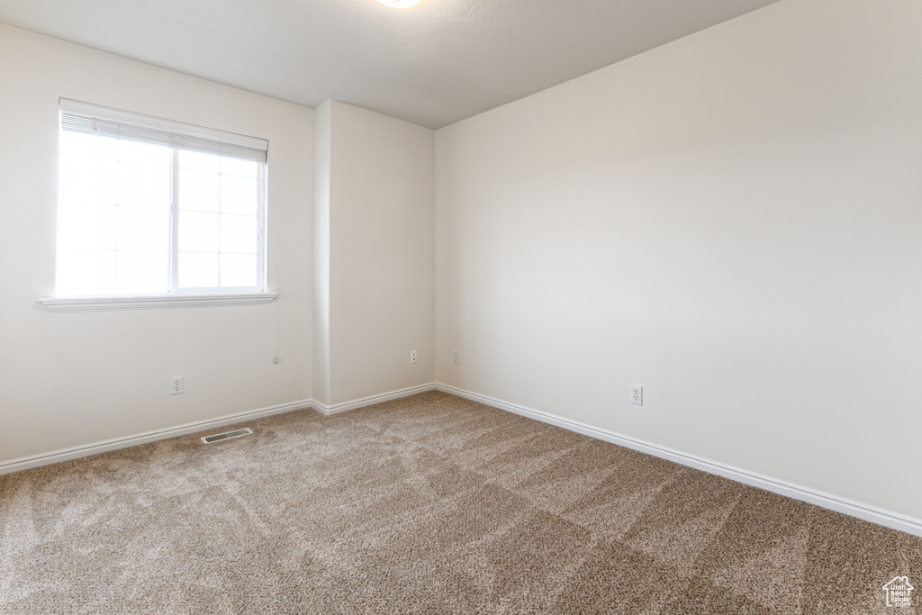 Carpeted empty room with baseboards