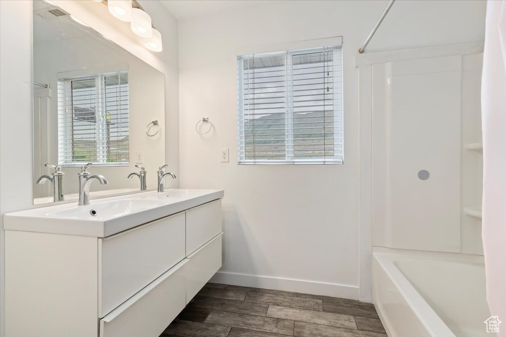 Bathroom with wood finished floors, baseboards, and double vanity