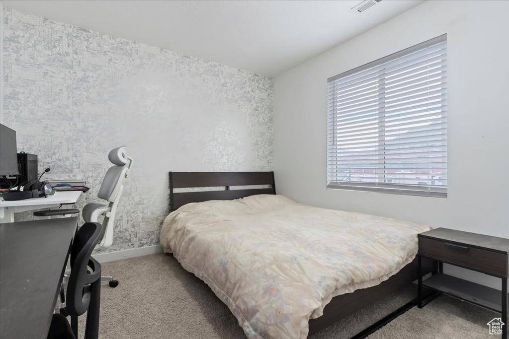 Bedroom featuring carpet floors, baseboards, and a desk
