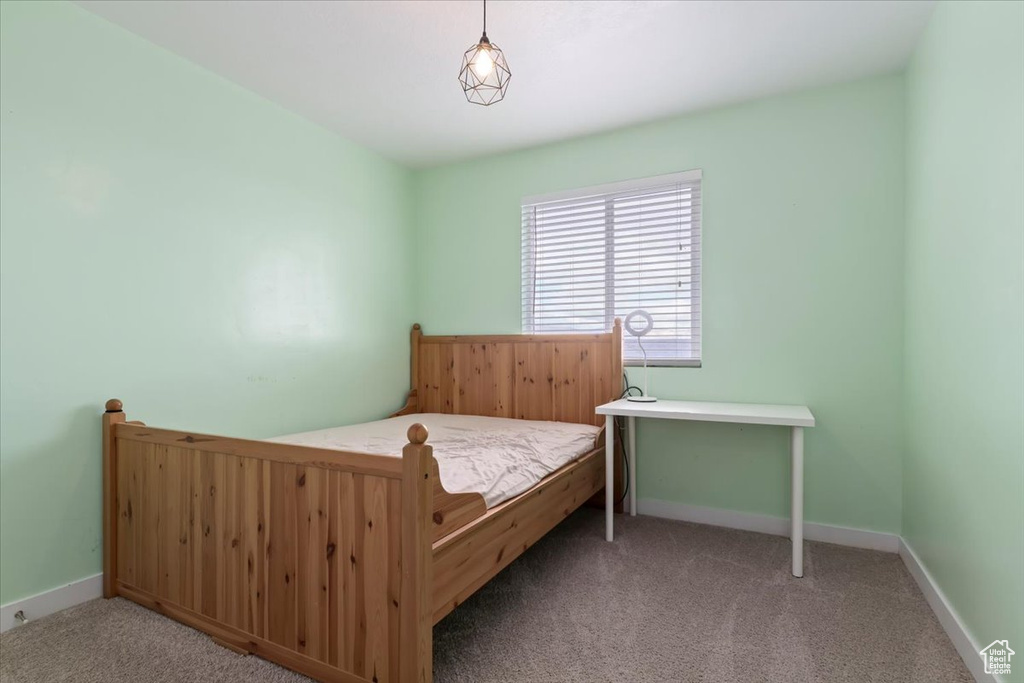 Bedroom featuring carpet and baseboards