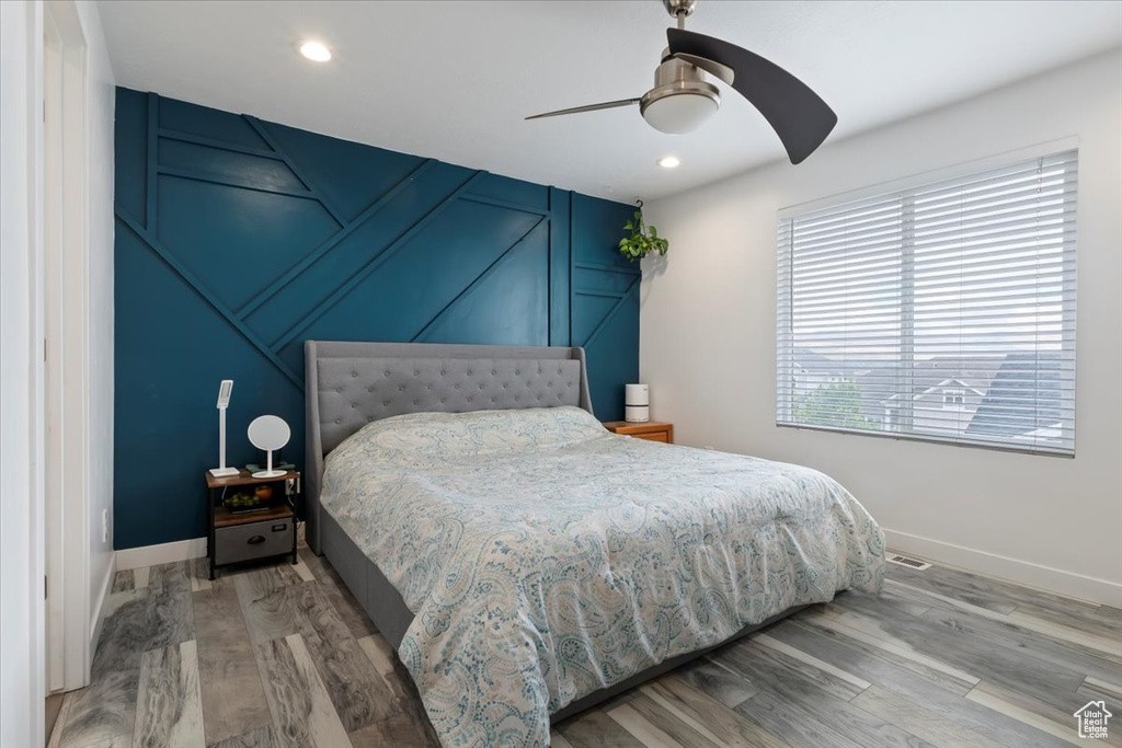 Bedroom with baseboards, wood finished floors, a ceiling fan, and recessed lighting