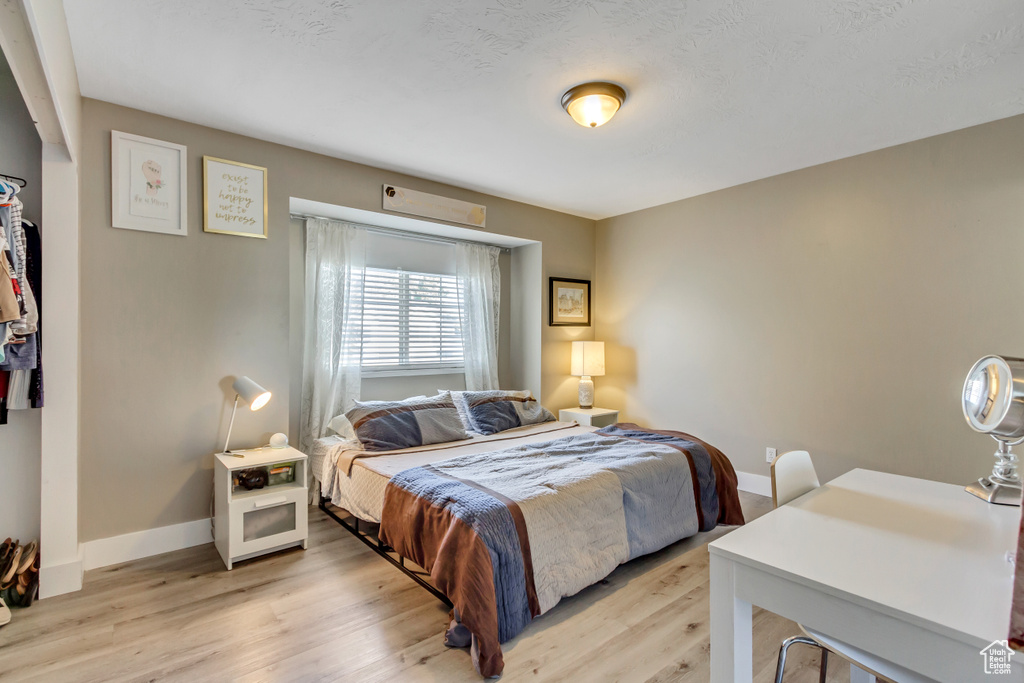 Bedroom featuring light wood-style flooring and baseboards