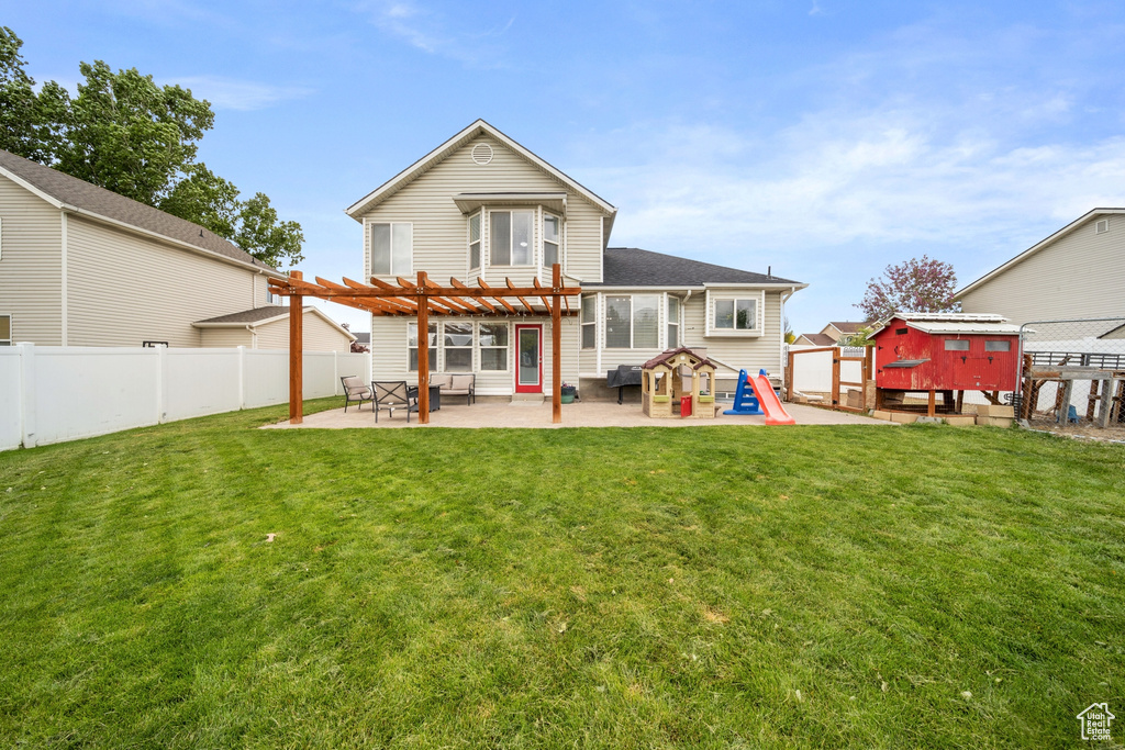 Rear view of property featuring a pergola, a patio, a storage shed, and an outbuilding