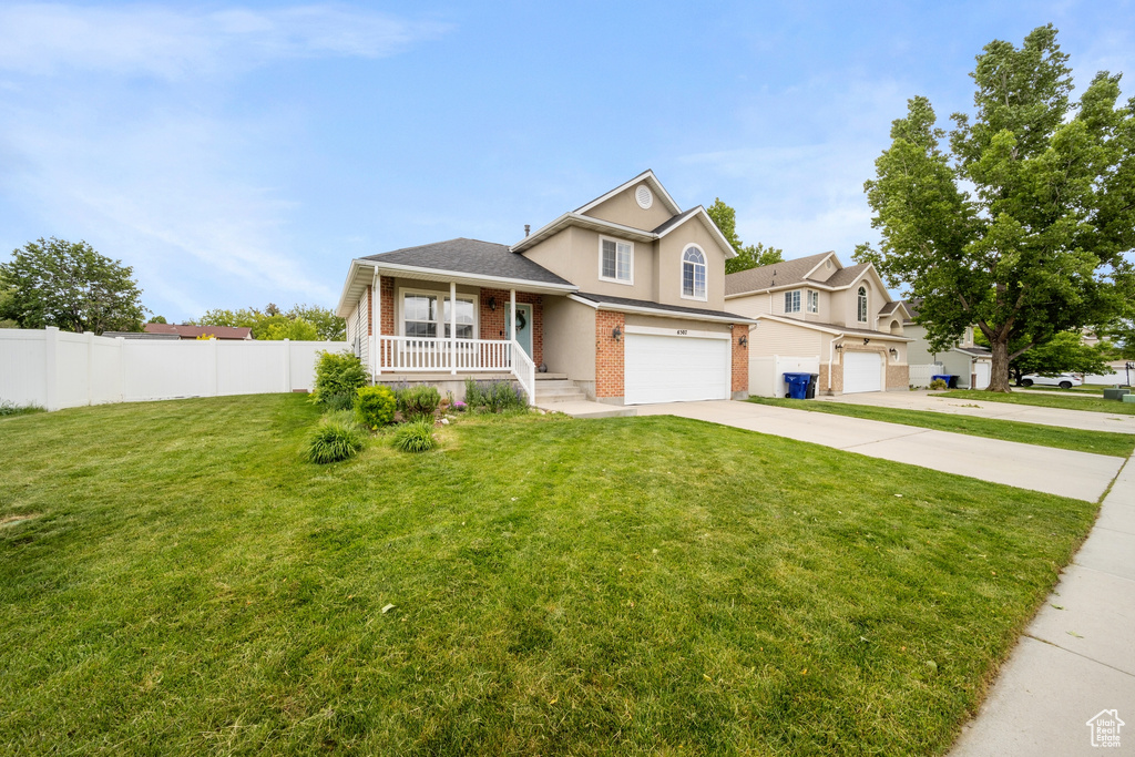 Split level home with brick siding, covered porch, an attached garage, concrete driveway, and a shingled roof