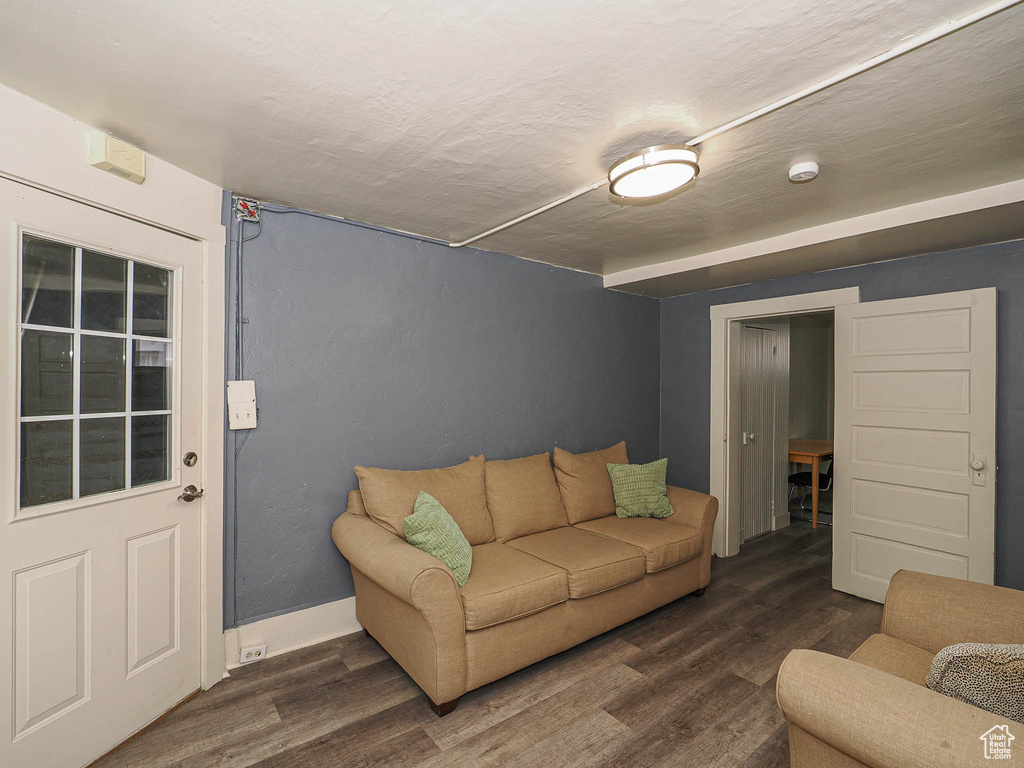 Living room featuring dark wood finished floors and baseboards